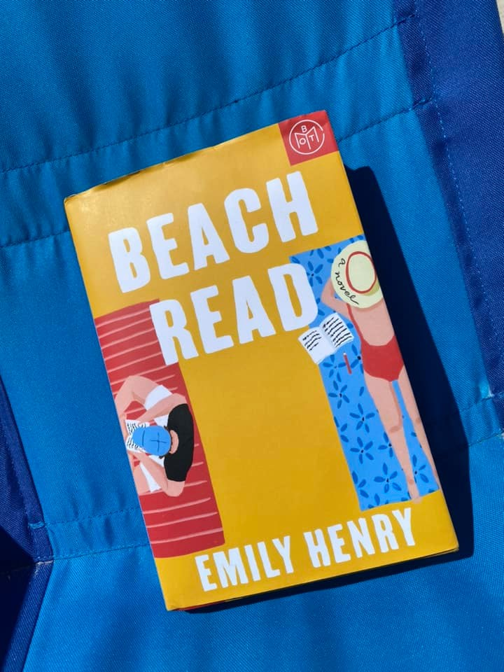 the book "beach read" by emily henry lying on a blue background